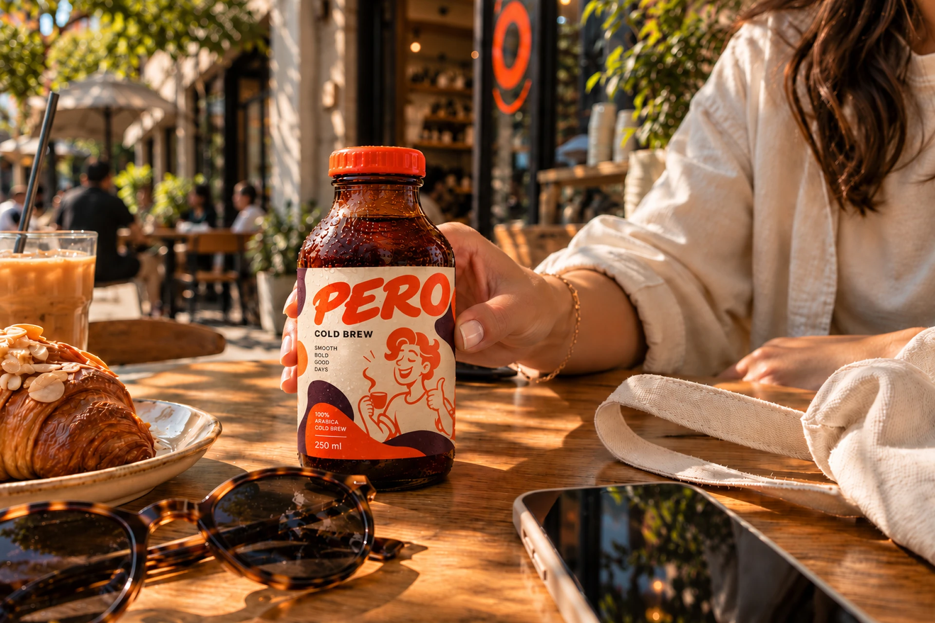 A Pero-branded bottled coffee on a sunlit café table